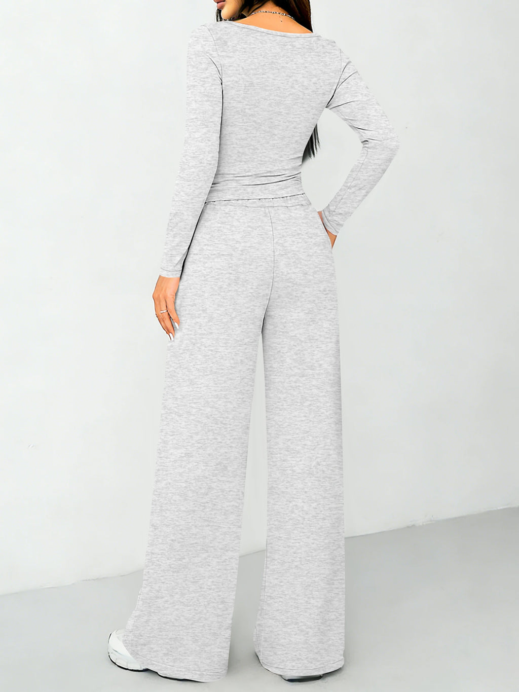 Modisches zweiteiliges Set für Damen: ein hochgeschlossenes, figurbetontes Langarm-Oberteil und weit geschnittene Hose mit Kordelzug.