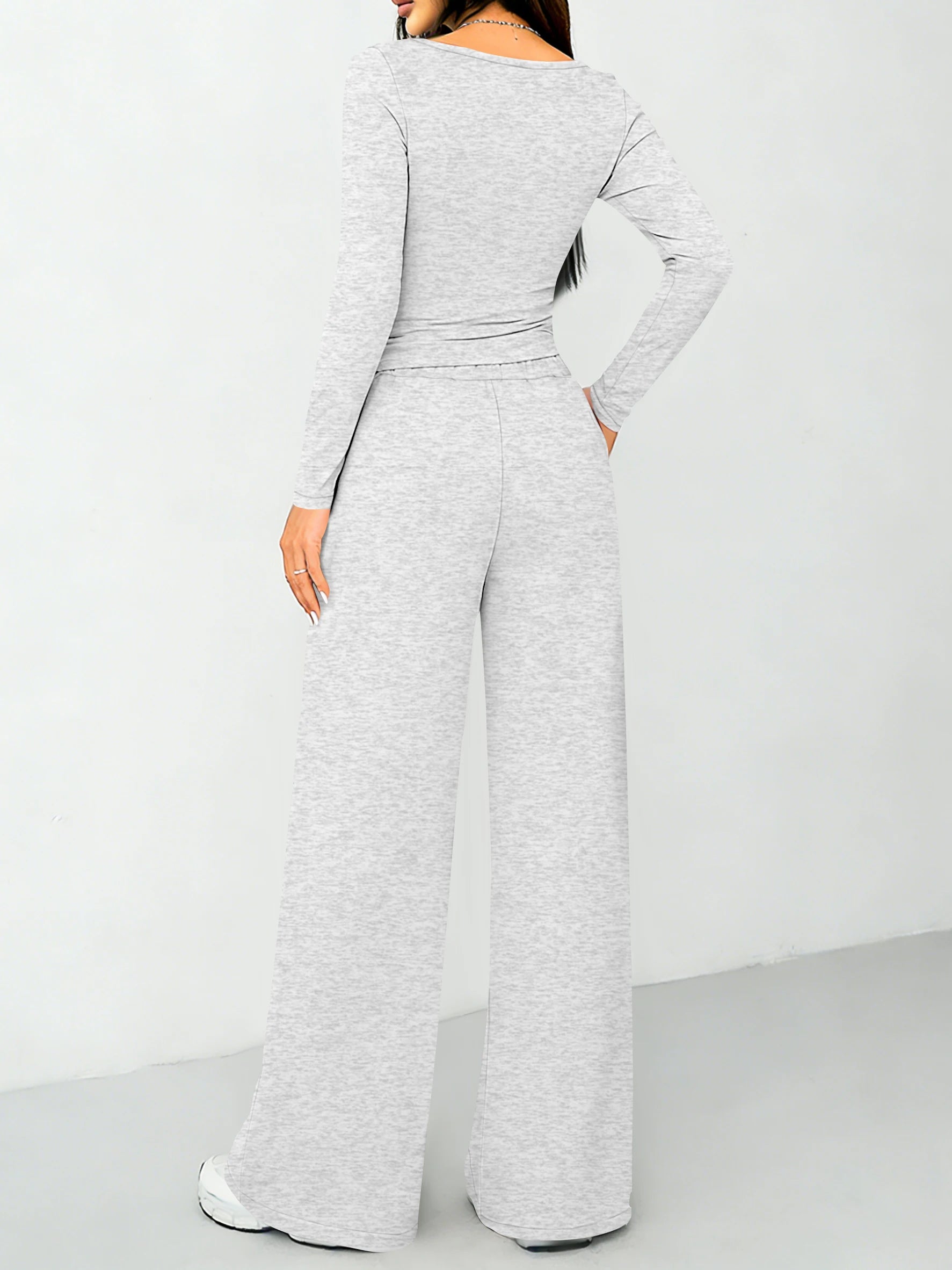Modisches zweiteiliges Set für Damen: ein hochgeschlossenes, figurbetontes Langarm-Oberteil und weit geschnittene Hose mit Kordelzug.