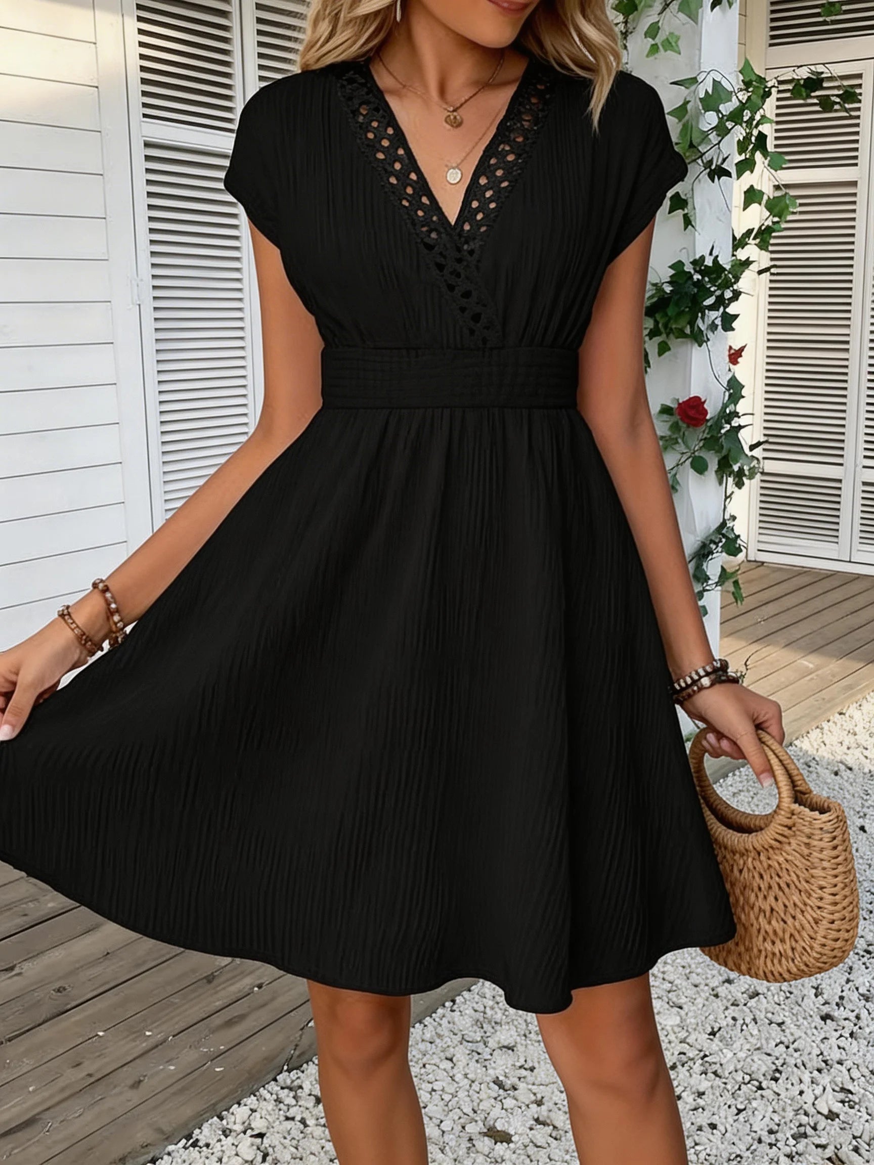 Französisches Spitzenkleid mit V-Ausschnitt, Taillierung und kurzen Puffärmeln. Kurzer Rock mit gestreifter Textur und vertikalen Linien. Strand-Street