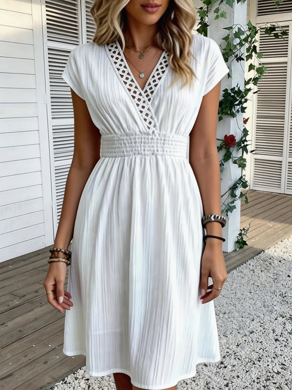 Französisches Spitzenkleid mit V-Ausschnitt, Taillierung und kurzen Puffärmeln. Kurzer Rock mit gestreifter Textur und vertikalen Linien. Strand-Street