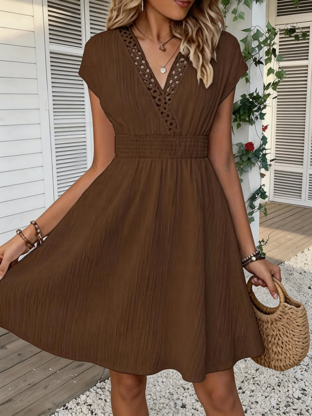 Französisches Spitzenkleid mit V-Ausschnitt, Taillierung und kurzen Puffärmeln. Kurzer Rock mit gestreifter Textur und vertikalen Linien. Strand-Street